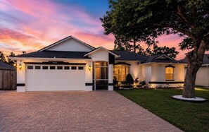 A residential house with a garage, a driveway, and a well-maintained lawn.