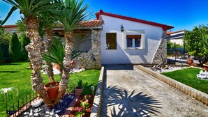 Una casa con facciata in pietra, tetto rosso e una piccola finestra.
