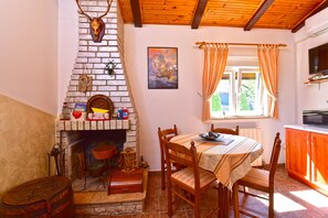 A rustic interior with a fireplace, wooden furniture, and a window with curtains. - House 2426/203980 (Istria - Fažana), 200m from the beach (Fažana)