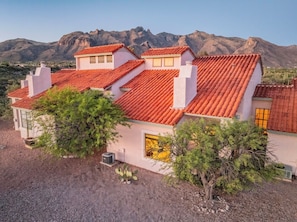 A multi-story building with red-tiled roofs, white walls, and a mountainous backdrop. - Hilltop Luxury Stay w/360° Views | 8mi from U of A (Tucson)