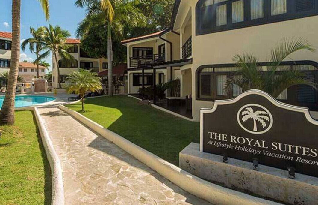 Un resort con un cartello che indica 'The Royal Suites' e una zona piscina.