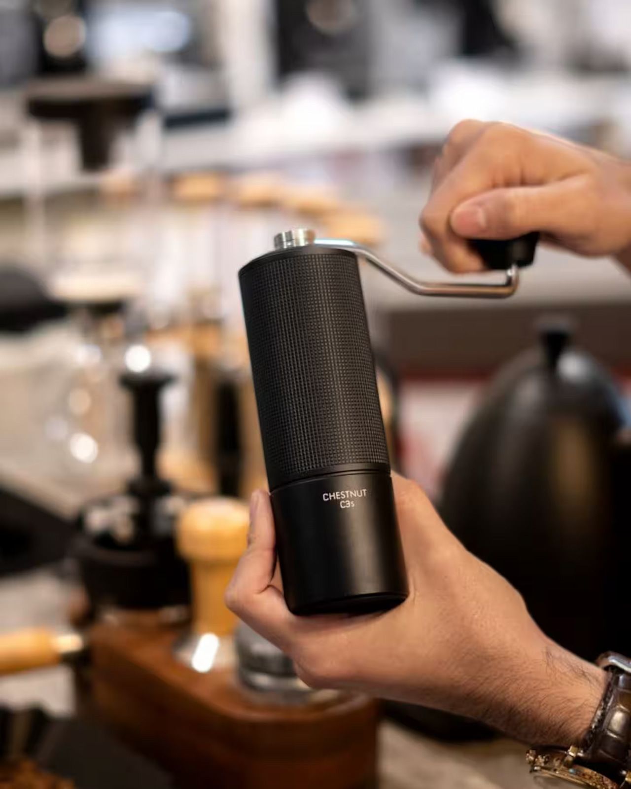 Une personne tient un objet cylindrique noir dont la surface est texturée et qui porte une étiquette indiquant « CHÂTAIGNE C35 ».