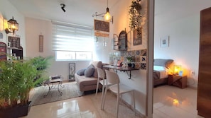 A cozy living room with a sofa, a coffee station, and a dining area. - Caffe Host Armenia Design apartment + Coffee experience and swimming pool (Armenia)