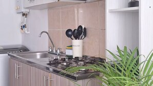 Una cocina moderna con una isla central, electrodomésticos de acero inoxidable y una variedad de utensilios.