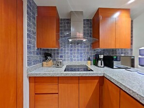 Eine Küche mit Holzausstattung, integriertem Mikrowellenherd, Kaffeemaschine und Wasserspender.