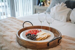 A wooden tray with a plate of snacks and two glasses on a bed. - Parkside Downtown Retreat | Walkable (Traverse City)