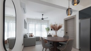 Een moderne woonkamer met een eethoek, een plafondventilator en een grote spiegel.