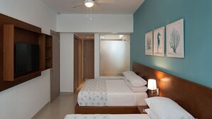 Habitación de hotel con dos camas, televisión, armarios de madera y una obra de arte en la pared.