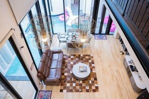 A modern living area with a leather sofa, round coffee table, and two pendant lights. - Moon 5-Bedroom Luxury Pool Villa (Pattaya)