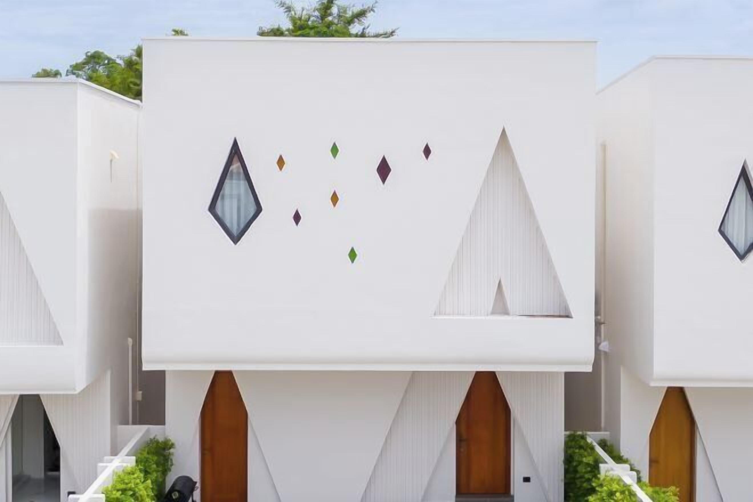 A modern building with geometric window shapes and a clean, white facade.