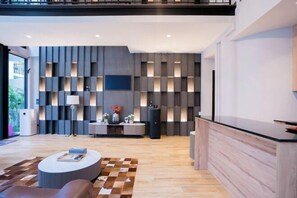 A modern interior with a central seating area, a kitchen counter, and a wall with recessed lighting. - Moon 5-Bedroom Luxury Pool Villa (Pattaya)