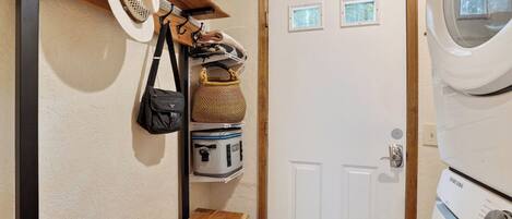 A laundry room with a washing machine, a dryer, and a door with small windows.