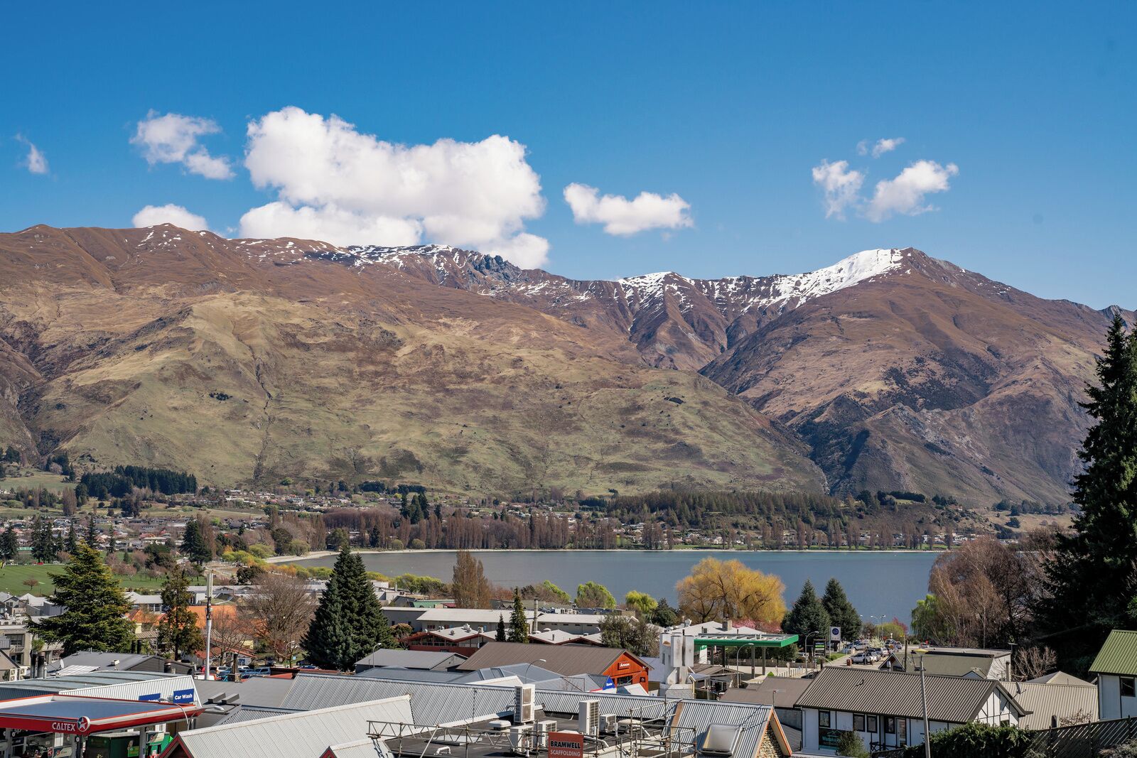 A town with a lake, mountains, and a mix of residential and commercial buildings.