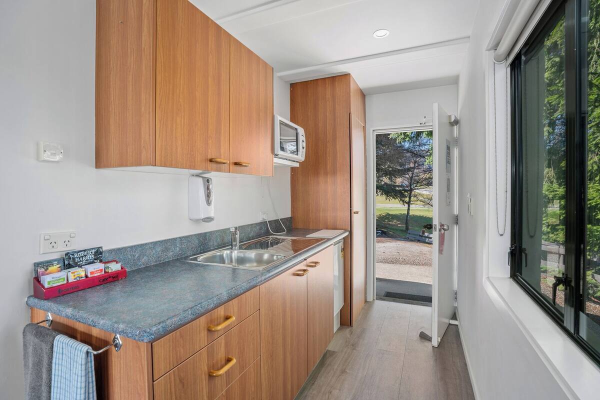 A modern kitchen with wooden cabinets, a granite countertop, and a built-in oven.