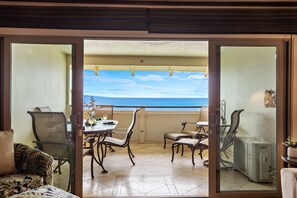 Ein Balkon mit Esstisch, Stühlen und Blick auf das Meer.
