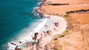 A coastal landscape with a beach, rocky shoreline, and a dirt path. - Reefwatch, Wall of Glass, Endless Ocean Views (Encounter Bay)