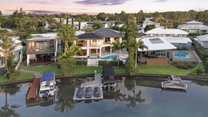 A residential area with houses, a dock, and a swimming pool. - Luxurious Impeccably Styled Waterfront Noosa Home (Noosa Region)