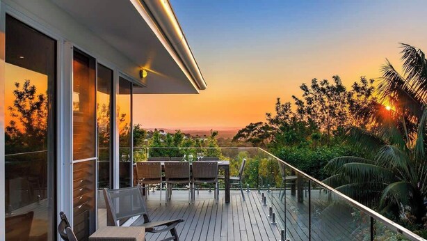 A modern building with a balcony overlooking a sunset. - Noosa Luxe Coastal Home with Panoramic Views (Noosa Region)