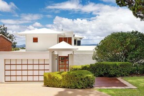 A modern two-story house with a garage, a small porch, and a well-maintained lawn. - Noosa Luxe Coastal Home with Panoramic Views (Noosa Region)