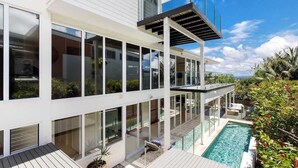 A modern two-story building with large windows, a pool, and a deck area. - Noosa Luxe Coastal Home with Panoramic Views (Noosa Region)