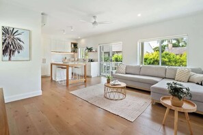 Ein modernes Wohnzimmer mit einer Couch, einem Couchtisch und einem Essbereich mit Tisch und Stühlen.
