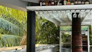 Zona de bar con una variedad de botellas de licores y vasos.