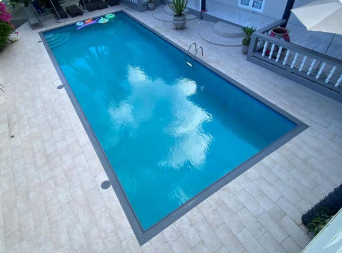 Una piscina al aire libre, sillones reclinables de piscina