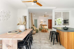 Una cocina moderna con una mesa de comedor de madera, taburetes negros y una isla de cocina.