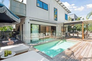 A modern house with a swimming pool, outdoor seating, and a balcony. - Ultimate Sunshine Beach Pad, Pet Friendly + Pool (Noosa Region)