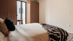 A bedroom with a bed, a wardrobe, and a sliding door to a balcony. - Beautiful House in San Miguel de Allende - Private (San Miguel de Allende)