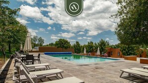 A swimming pool with lounge chairs and umbrellas, surrounded by trees and a clear sky. - Beautiful House in San Miguel de Allende - Private (San Miguel de Allende)