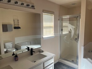 Douche, baignoire à remous, séchoir à cheveux, serviettes fournies