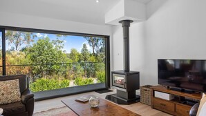 Una sala de estar moderna con un ventanal grande, una chimenea y un televisor.