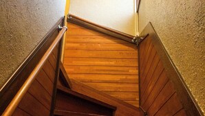 A wooden staircase with metal handrails, leading to a landing. - Shiki House (Shiki)
