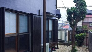 A modern building with large windows and a small tree in the yard. - Shiki House (Shiki)
