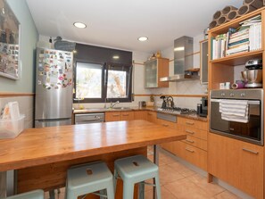 A kitchen with a wooden countertop, stainless steel appliances, and a window with a view. - Can Jamy by Costabravaway (calonge)