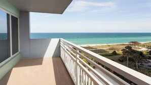 Een balkon met uitzicht op de oceaan en het strand.