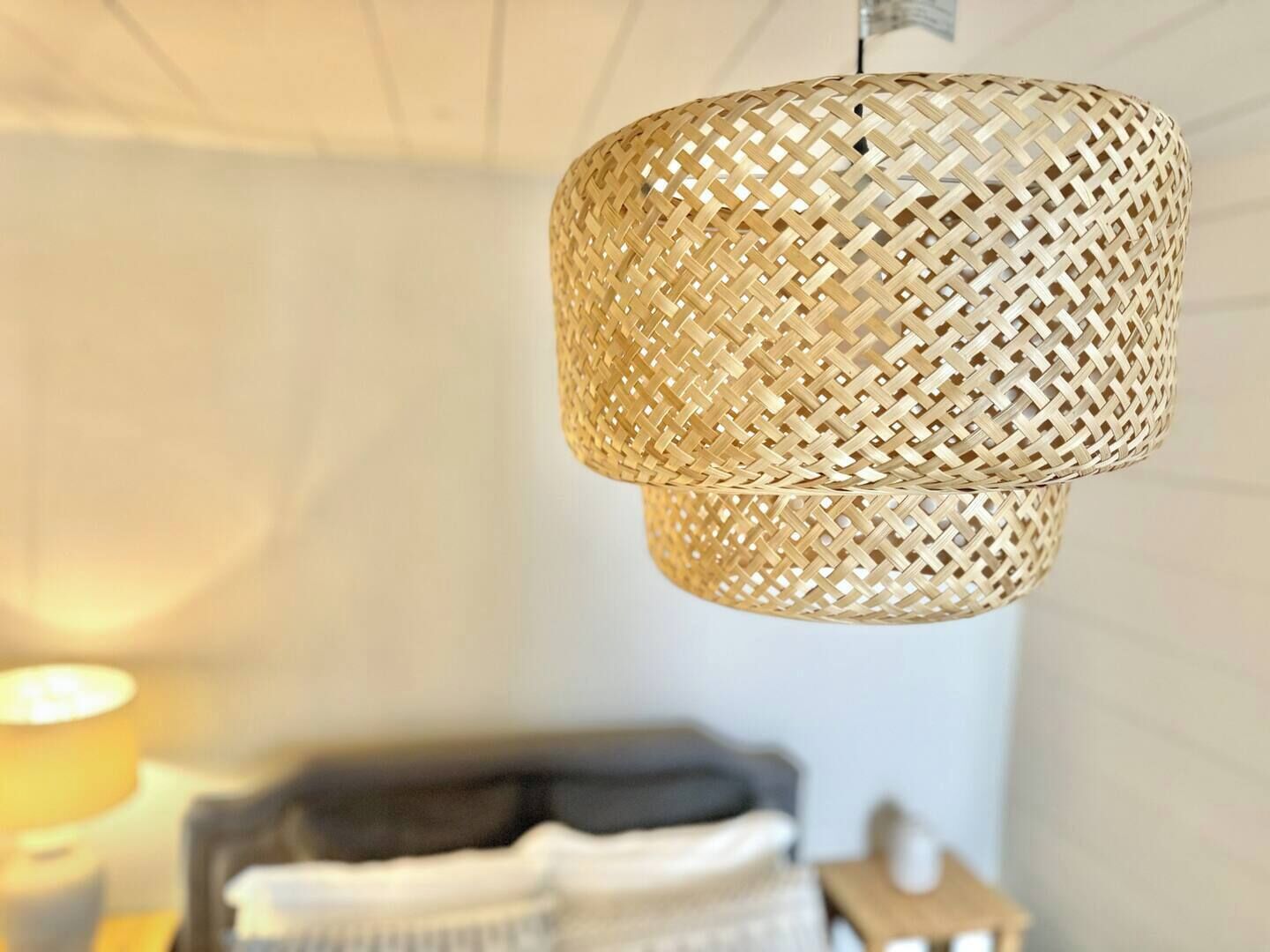 A woven rattan pendant light fixture in a room.