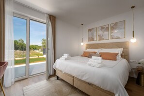 A bedroom with a large bed, a sliding glass door to a balcony, and a view of greenery. - Villa Eufemia Perci (Istria - Poreč) (Poreč)
