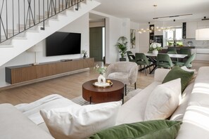 A modern living room with a sofa, armchairs, a coffee table, and a TV mounted on the wall. - Villa Eufemia Perci (Istria - Poreč) (Poreč)
