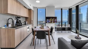 A modern kitchen with a dining area, large windows, and a view of the cityscape. - Modern High Rise Stay- 23 Floor Views (Miami)