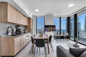 A modern kitchen with a dining area, large windows, and a view of the cityscape. - Modern High Rise Stay- 23 Floor Views (Miami)