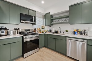 A modern kitchen with a built-in oven, microwave, and dishwasher. - Modern Highland Park Home with 3 Ensuite Bedrooms, Patio & BBQ (Los Angeles)