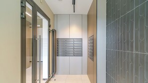 A hallway with a glass door, a wall-mounted mail slot, and a patterned wall. - Sowińskiego Modern Studio (Gliwice)