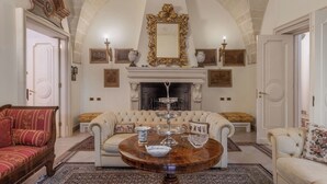 Una habitación con chimenea, sofá, una mesa de centro y un espejo.