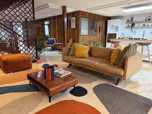 A modern living room with a sofa, ottoman, coffee table, and a kitchen area in the background. - SANTA MONICA HOUSE IN LA DEL VALLE FOR THE WORLD CUP (Ciudad de México)