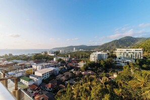 A coastal town with buildings, a clear sky, and a view of the sea. - Stunning Sea-View Penthouse w/ Pool C80 (Tambon Karon)