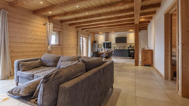 A wooden interior with a sofa, dining table, kitchen area, and a large window. - La Seille - HAUTELUCE (HAUTELUCE)