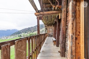 Ein Holzbalkon mit Blick auf eine gebirgige Landschaft.