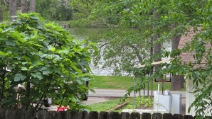 A residential area with a pond, a wooden fence, and a house with a garage. - Peaceful Lake Guesthouse (Montgomery)